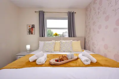 a dog laying in a tray on a bed at Highwoods Haven Luxury Stay with Garden and Parking in Mile End