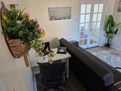 a living room with a couch and a table with flowers at Highwoods Haven Luxury Stay with Garden and Parking in Mile End
