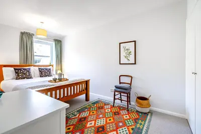 a living room with a bed and a chair at Brunswick Terrace in Cambridge