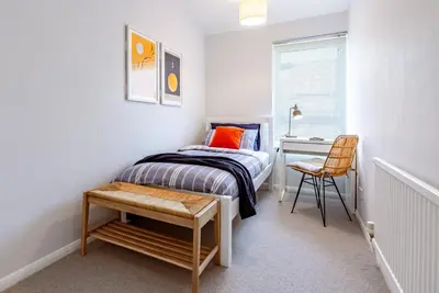 a small bedroom with a bed and a desk at Brunswick Terrace in Cambridge