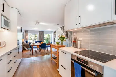 a kitchen with white cabinets and a dining room at Brunswick Terrace in Cambridge