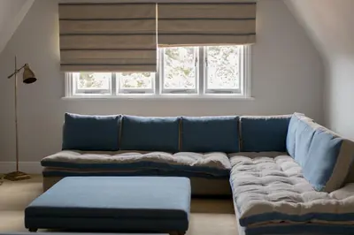 a blue couch in a living room with a window at Royal Racing Retreat in Newmarket in Newmarket