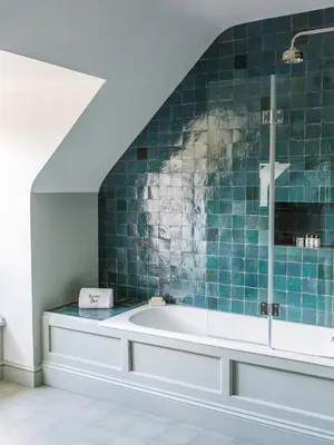 a bathroom with a tub with a green tiled wall at Royal Racing Retreat in Newmarket in Newmarket