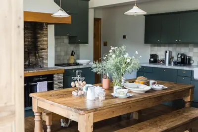 a wooden table in a kitchen with green cabinets at Royal Racing Retreat in Newmarket in Newmarket