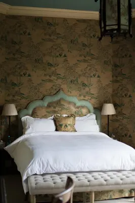 a bedroom with a bed with white sheets and floral wallpaper at Royal Racing Retreat in Newmarket in Newmarket