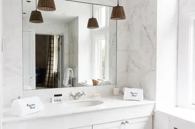 a white bathroom with a sink and a mirror at Royal Racing Retreat in Newmarket in Newmarket