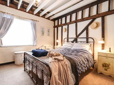 a bedroom with a bed and a large window at Driftwood Cottage in Harwich