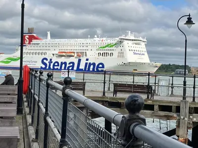 a large cruise ship is docked at a dock at Driftwood Cottage in Harwich
