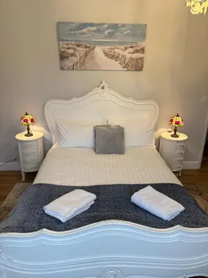 a bedroom with a bed with two tables and two lamps at Sami in Southend-on-Sea