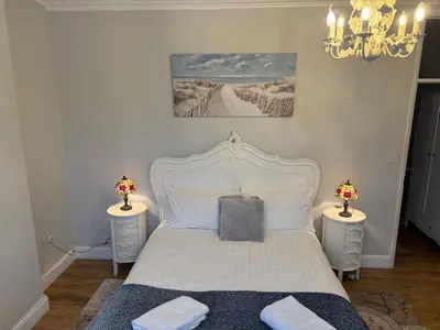 a bedroom with a white bed with two night stands at Sami in Southend-on-Sea