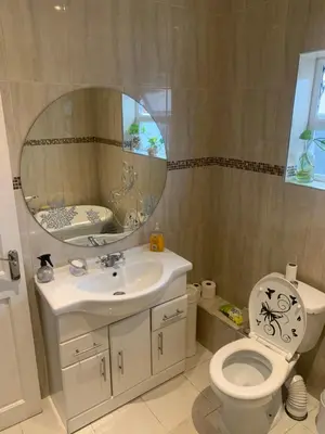 a bathroom with a sink and a toilet and a mirror at Sami in Southend-on-Sea