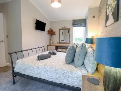 a bedroom with a bed with blue pillows at Wurzburc in Swaffham
