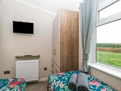 a bedroom with a bed and a window and a tv at Wurzburc in Swaffham