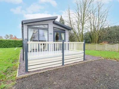 a small shed with a white fence in a yard at Wurzburc in Swaffham