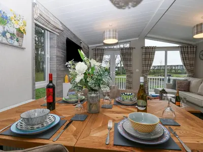 a dining room table with plates and wine bottles on it at Wurzburc in Swaffham