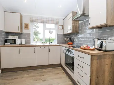 a kitchen with white cabinets and a window at Wurzburc in Swaffham
