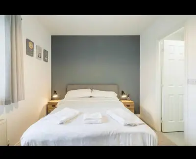 a bedroom with a white bed with two towels on it at Chique & Modern Style Apartment in Cambridge