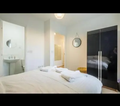 a white bedroom with a bed and a sink at Chique & Modern Style Apartment in Cambridge