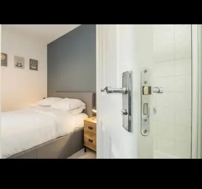 a bedroom with a white bed and a shower at Chique & Modern Style Apartment in Cambridge