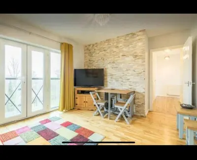 a living room with a table and a television at Chique & Modern Style Apartment in Cambridge