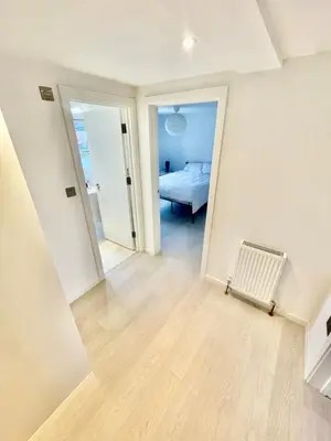 an empty room with a bed and a hallway at Modern 2 bedroom apartment in cambridge in Milton