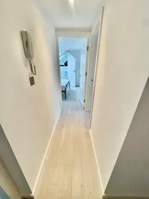 a hallway with a phone hanging on a wall at Modern 2 bedroom apartment in cambridge in Milton