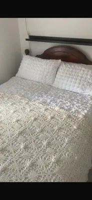 a bed with a white comforter and a pillow at Chestnut Cottage in Great Ellingham