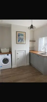 a kitchen with a sink and a washing machine at Chestnut Cottage in Great Ellingham