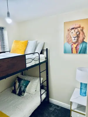 a room with two bunk beds with a lion picture on the wall at Spacious 3BR Home in Colchester, with Private Parking in Colchester