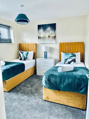 a bedroom with two beds with blue and white sheets at Spacious 3BR Home in Colchester, with Private Parking in Colchester