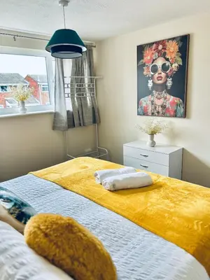 a bedroom with a bed with a painting of a woman at Spacious 3BR Home in Colchester, with Private Parking in Colchester