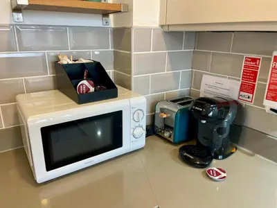 a microwave sitting on a counter next to a blender at Central Leigh, on the Broadway, private gated parking, balcony in Southend-on-Sea