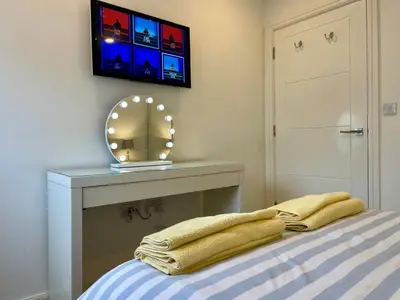 a bedroom with a bed with a mirror and a tv at Central Leigh, on the Broadway, private gated parking, balcony in Southend-on-Sea