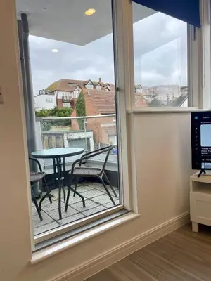 a room with a window with a table and a table at Central Leigh, on the Broadway, private gated parking, balcony in Southend-on-Sea