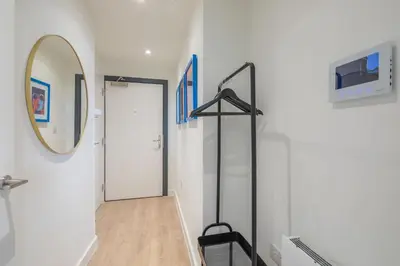 a hallway with a mirror and a door at Fabulous Central Apt With Balcony & Parking in Cambridge
