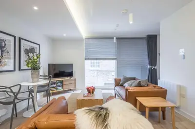 a living room with a couch and a table at Stunning Central Apt With Parking in Cambridge