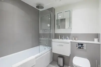 a white bathroom with a sink and a shower at Stunning Central Apt With Parking in Cambridge