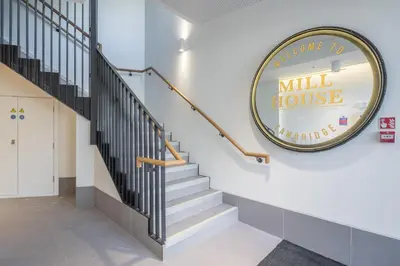a lobby with stairs and amill house sign on the wall at Stunning Central Apt With Parking in Cambridge