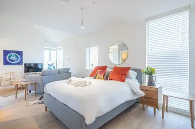 a bedroom with a large bed and a mirror at Luxury Central Apt Riverside Views & Parking in Cambridge