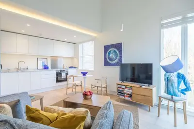 a living room with a couch and a tv at Luxury Central Apt Riverside Views & Parking in Cambridge