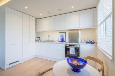 a kitchen with white cabinets and a bowl on a table at Luxury Central Apt Riverside Views & Parking in Cambridge