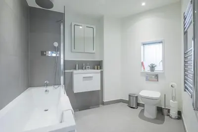 a bathroom with a tub and a toilet and a sink at Superb Central Apt River Views & Parking in Cambridge
