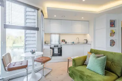 a living room with a green couch and a table at Superb Central Apt River Views & Parking in Cambridge