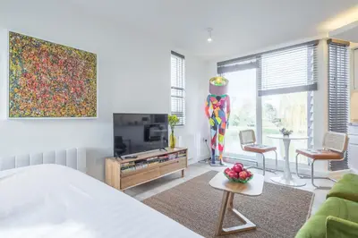 a bedroom with a bed and a tv and a table at Superb Central Apt River Views & Parking in Cambridge