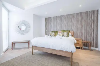 a bedroom with a large bed and a mirror at Stunning Central Apt - Balcony & Parking in Cambridge