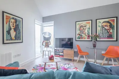 a living room with a blue couch and orange chairs at Superb Central Apt With Parking in Cambridge