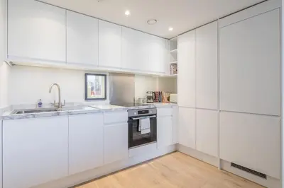 a kitchen with white cabinets and a sink at Superb Central Apt With Parking in Cambridge