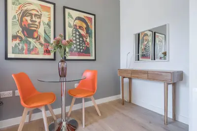 a dining room with a table and orange chairs at Superb Central Apt With Parking in Cambridge