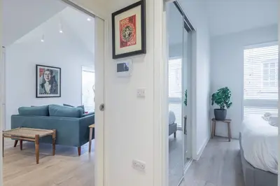 a living room with a blue couch and a bed at Superb Central Apt With Parking in Cambridge