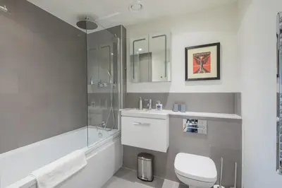 a white bathroom with a toilet and a sink at Superb Central Apt With Parking in Cambridge